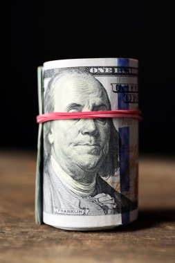 Koyu arka plan önünde ahşap masa dolar rulo