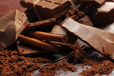 İle baharat ahşap arka plan üzerinde siyah çikolata parçaları