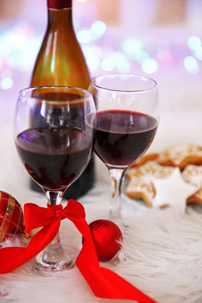 Botella y copas de vino con decoración navideña contra coloridas luces bokeh fondo —  Fotos de Stock