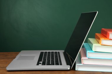 Dizüstü bilgisayar ile kitap yığını