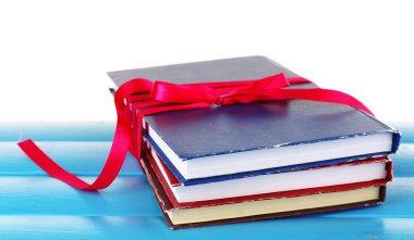 Tablo üzerinde beyaz izole kurdele ile kitap yığını
