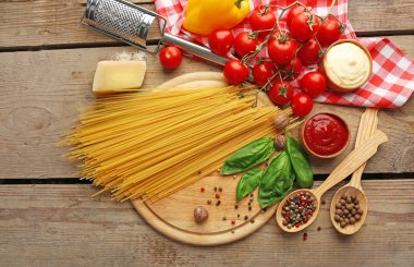 Makarna spagetti domates, peynir ve fesleğen rustik ahşap zemin üzerine