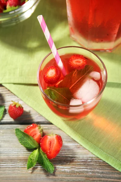 Pot plein et verre de jus de fraise avec des baies sur la table fermer — Photo