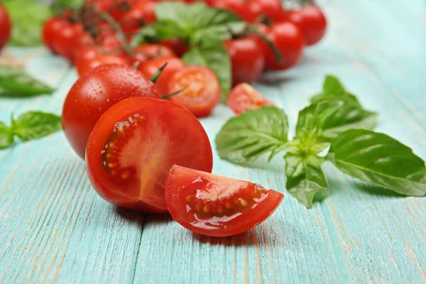 Świeże pomidory z bazylią na drewnianym stole z bliska — Zdjęcie stockowe