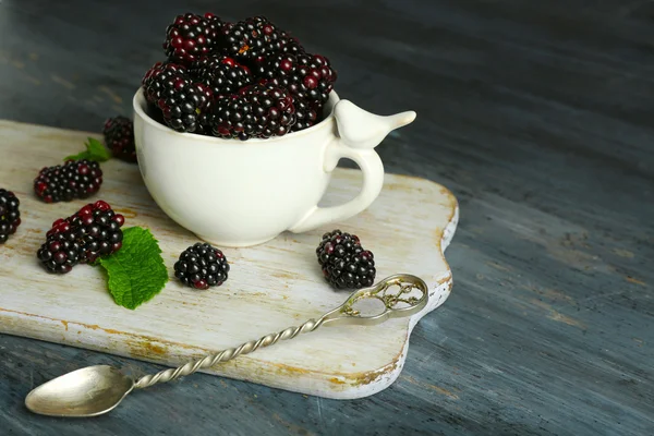 Un mucchio di more dolci con menta in tazza sul tavolo da vicino — Foto Stock