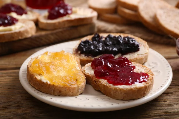 Fresh toast with butter and different jams on table close up — Stock Photo, Image