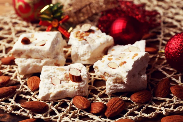 Turrón dulce con almendras y mesa de decoración de Navidad de cerca —  Fotos de Stock