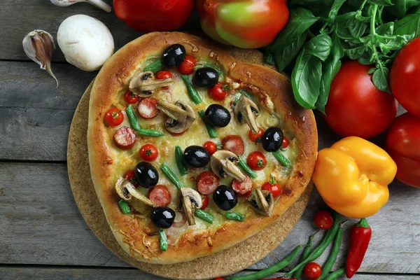 Delicious heart shaped pizza with vegetables on wooden background, close up — Stock Photo, Image