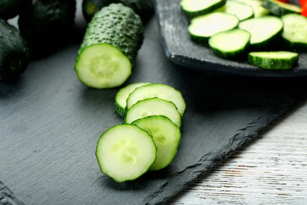 Sliced cucumbers on black background, close up — Stock Photo, Image