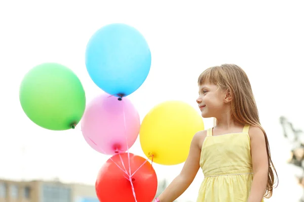 Liten flicka med ballonger — Stockfoto