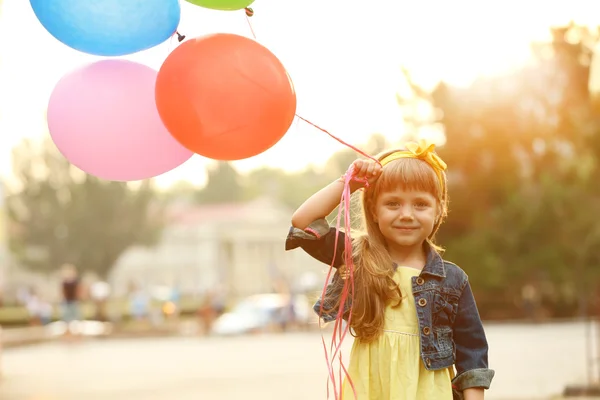 Liten flicka med ballonger — Stockfoto