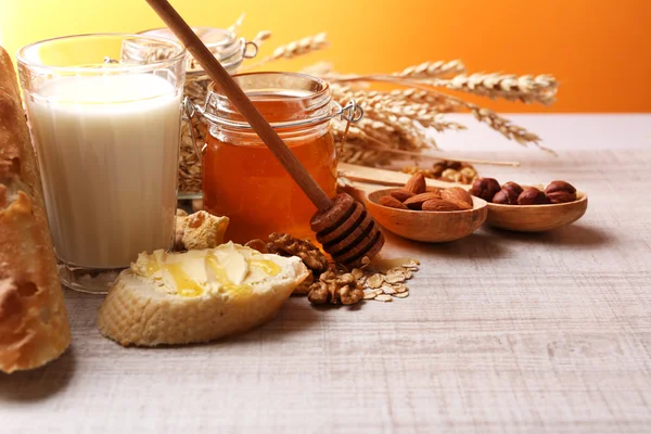 Hälsosam frukost med bröd, honung, nötter på bord, på färgstarka bakgrund. Frukost begreppet — Stockfoto