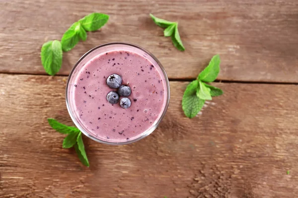 Frischer Blaubeerjoghurt mit Beeren und Minze auf Holzgrund dekoriert — Stockfoto