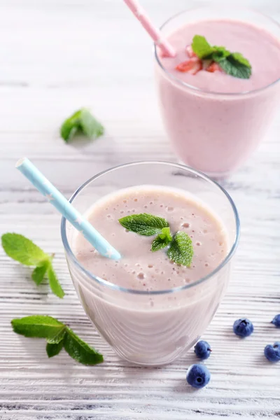 Свежий клубничный и молочный йогурты с мятой на светлом деревянном фоне — стоковое фото