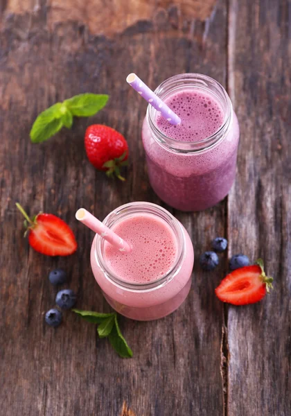 Healthy strawberry yogurt with mint and berries around on wooden background — Stock Photo, Image