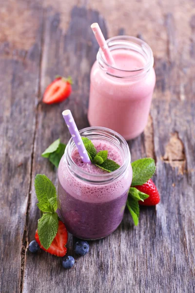 Здоровый клубничный йогурт с мятой и ягодами на деревянном фоне — стоковое фото