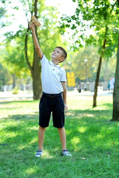 Niño juega con avión de madera — Foto de Stock