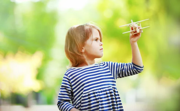 Küçük kız ile ahşap uçak çalış — Stok fotoğraf