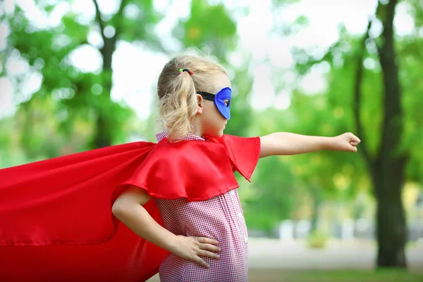 Supersankari pieni tyttö puistossa — kuvapankkivalokuva