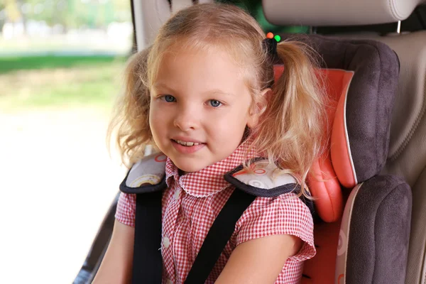 Pequena loira sentada no carro — Fotografia de Stock