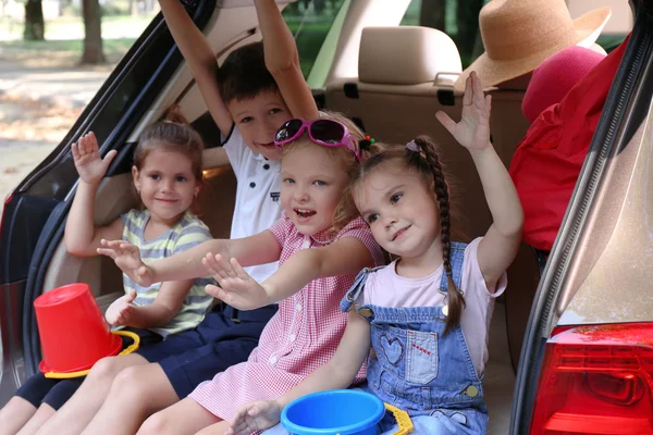 Kinderen zitten op de auto kofferbak — Stockfoto