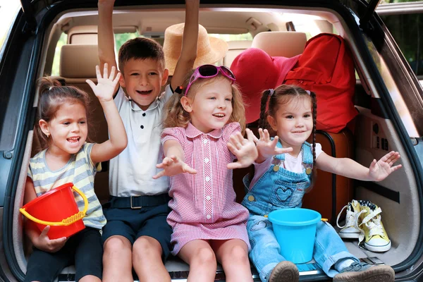 Mutlu çocuk araba gövde üzerinde oturmak — Stok fotoğraf