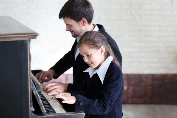 Lärare tränar att spela piano flicka — Stockfoto