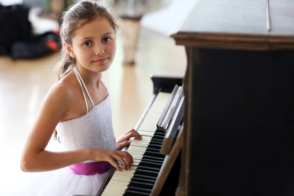 Pequena princesa menina toca piano — Fotografia de Stock