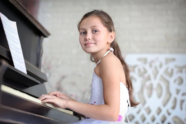 Prinses meisje speelt piano — Stockfoto