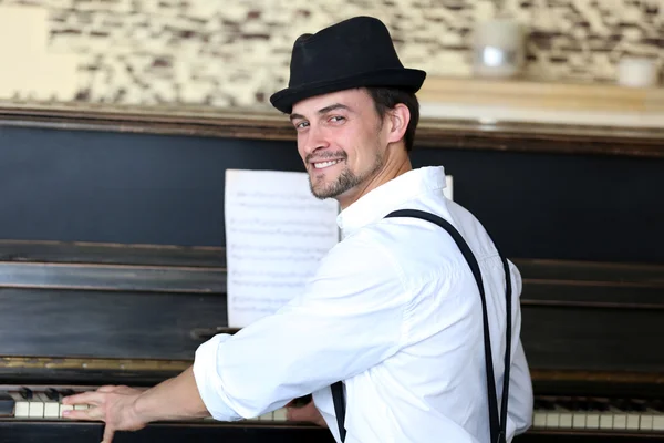 Junger Mann mit Hut posiert mit Klavier — Stockfoto
