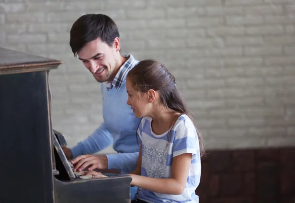 Professor e menina tocar piano — Fotografia de Stock