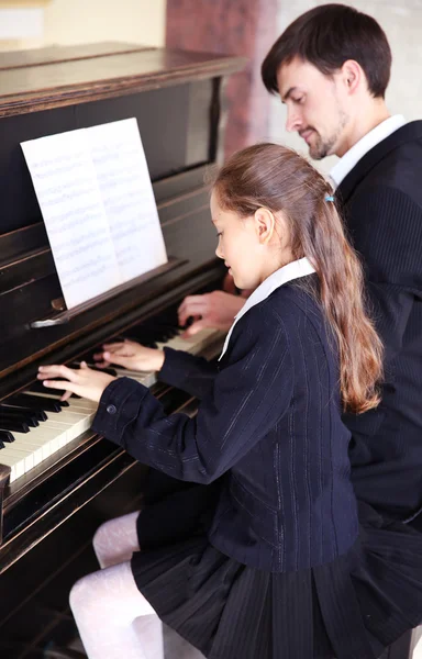Profesor entrena para tocar el piano niña — Foto de Stock