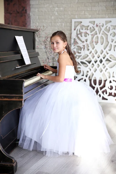 Prinses meisje in jurk speelt piano — Stockfoto
