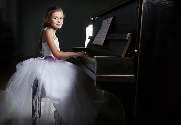 Pequeña princesa chica toca el piano — Foto de Stock