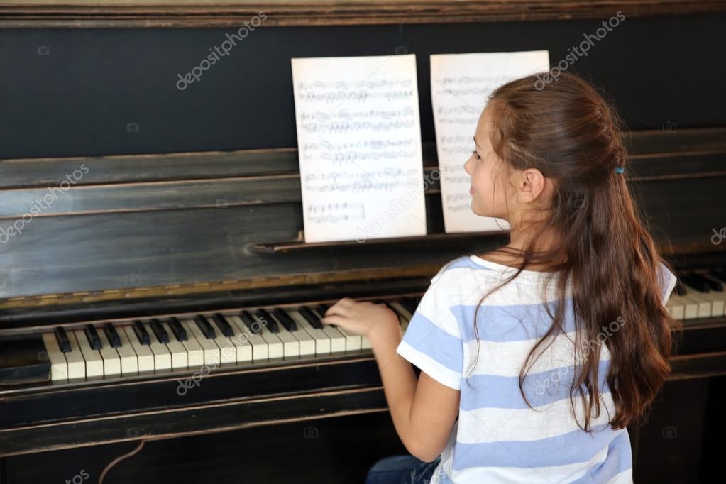 little musician girl plays piano