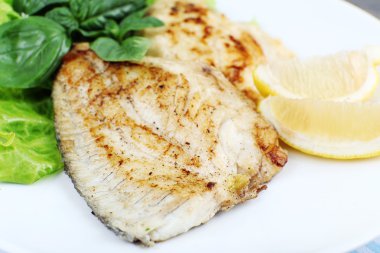 Balık fileto Yeşiller ve plaka üzerinde limon ile tabak kapat