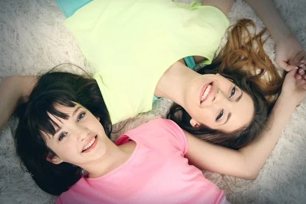 Дві дівчини лежать на килимі — стокове фото