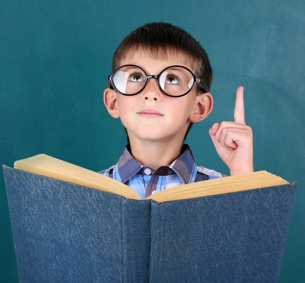 Schüler mit Buch an der Tafel — Stockfoto