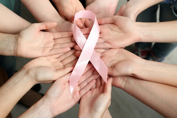 Grupo de manos femeninas con cinta rosa — Foto de Stock