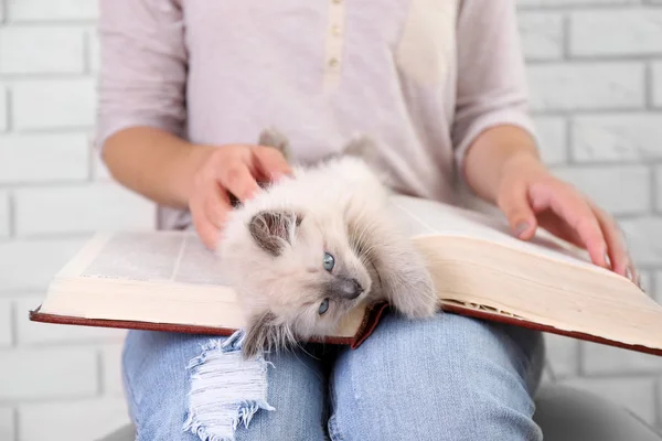 woman holding cat and old book