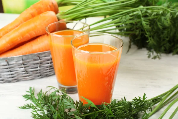 Szklanki soku z marchwi z warzywami na stole z bliska — Zdjęcie stockowe