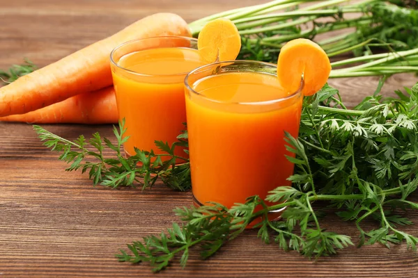 Glasögon med morotsjuice med grönsaker på bordet på nära håll — Stockfoto