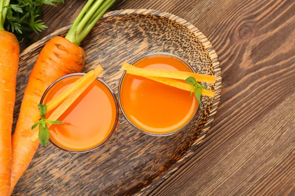 Glasses of carrot juice with vegetables on table close up — Stock Photo, Image