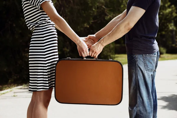 Casal segurando mala vintage ao ar livre — Fotografia de Stock