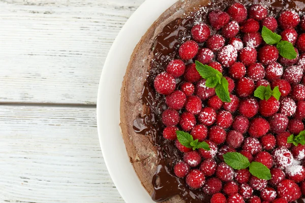 Torta csokoládé máz és a málna, a fából készült háttér — Stock Fotó