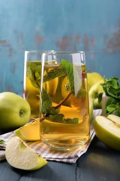 Vasos de jugo de manzana con frutas y menta fresca en la mesa de cerca —  Fotos de Stock