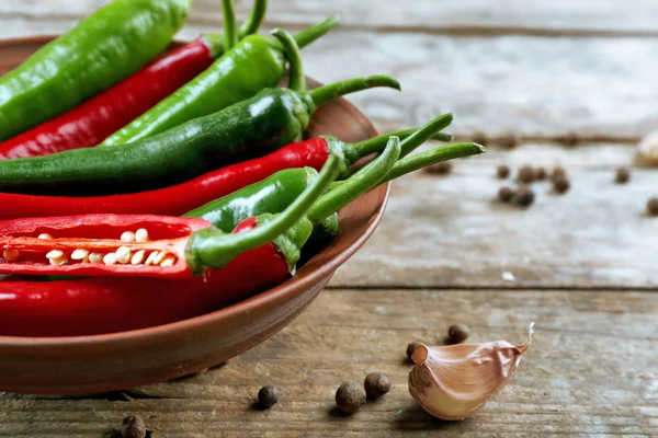 Hete pepers met kruiden op houten tafel close-up — Stockfoto