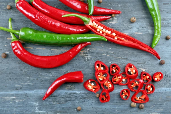 Varm paprika med kryddor på träbord nära håll — Stockfoto