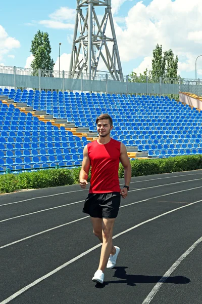 Ung man jogging på stadium — Stockfoto