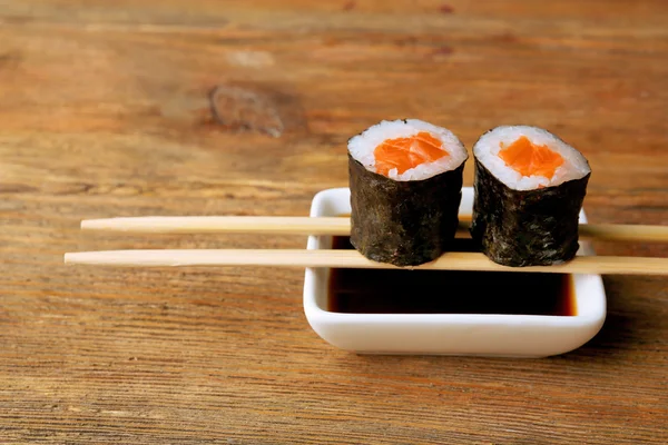 Rouleaux avec sauce et bâtons sur table en bois fermer — Photo